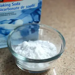 Un bol de bicarbonate de soude, connu pour aider à la digestion, à côté de sa boîte.