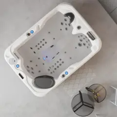Un spa écologique moderne, avec des jets lumineux, dans un salon épuré. Un canapé gris et une étagère complètent la scène.
