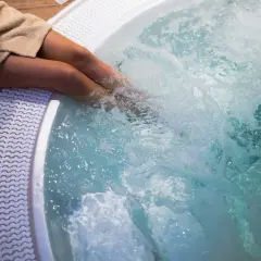 Personne dans un jacuzzi bouillonnant. Pour savoir comment éteindre un jacuzzi, consultez le manuel d'utilisation.