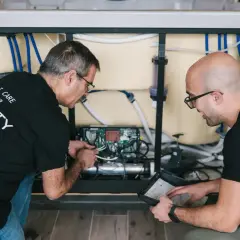 Deux techniciens travaillent sur le système électrique d'un spa, une étape clé pour savoir comment monter un spa.