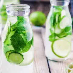 Bouteilles d'eau infusée de concombre et de menthe, une boisson rafraîchissante parfaite pour une infusion ayurvédique.