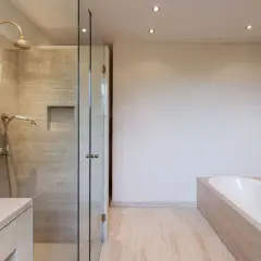 Salle de bain moderne avec douche vitrée et baignoire îlot, un véritable espace cocooning.