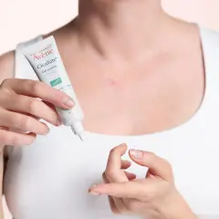 Une femme applique le gel cicatriciel Avène Cicalfate+, la meilleure crème pour cicatrice après opération, sur une légère cicatrice.