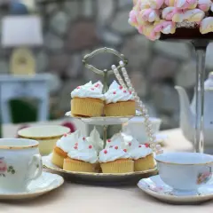 Délicieux cupcakes ornés de crème et de perles rouges, prêts pour un moment de tea time tradition.