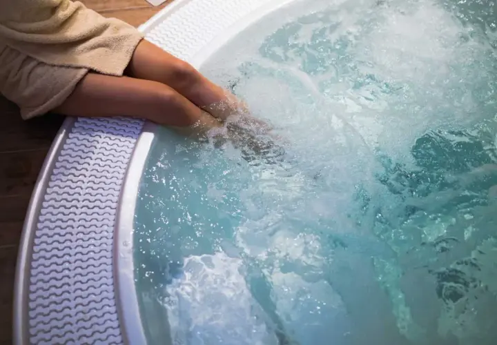 Personne dans un jacuzzi bouillonnant. Pour savoir comment éteindre un jacuzzi, consultez le manuel d'utilisation.