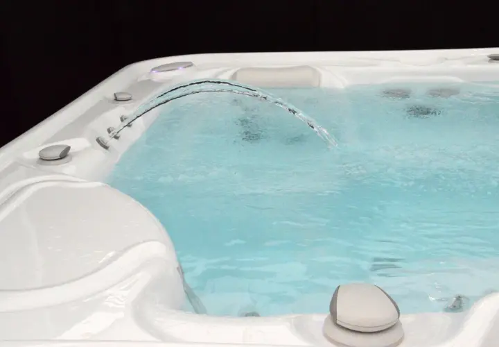 Un jet d'eau forme un arc gracieux au-dessus de l'eau trouble du spa, invitant à la détente.