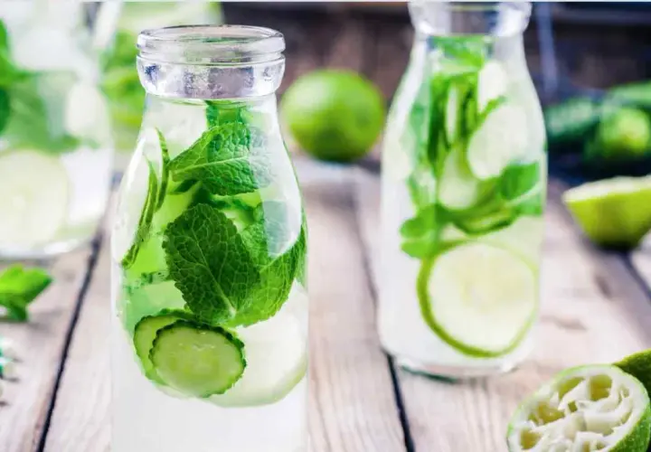 Bouteilles d'eau infusée de concombre et de menthe, une boisson rafraîchissante parfaite pour une infusion ayurvédique.