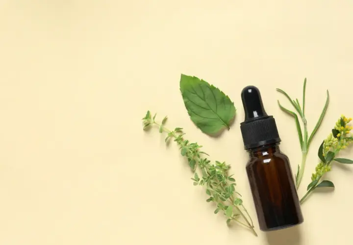 Flacon d'huile essentielle avec des herbes. Un remède naturel pour la toux sèche.