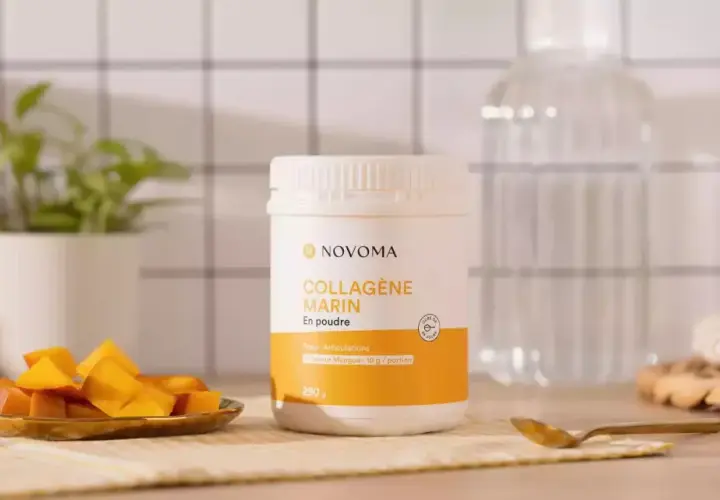 Un pot de cure de collagène marin en poudre saveur mangue, accompagné de dés de mangue fraîche.