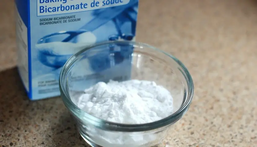 Un bol de bicarbonate de soude, connu pour aider à la digestion, à côté de sa boîte.