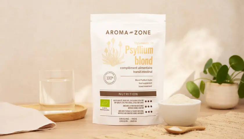 Un sachet de téguments de psyllium blond Aroma-Zone, un verre d'eau et une coupelle de poudre. Idéal pour le transit intestinal.