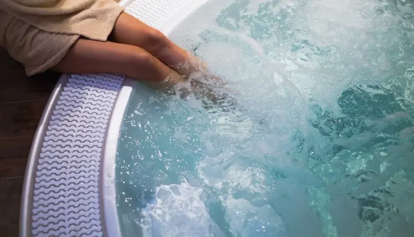 Personne dans un jacuzzi bouillonnant. Pour savoir comment éteindre un jacuzzi, consultez le manuel d'utilisation.