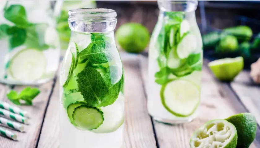 Bouteilles d'eau infusée de concombre et de menthe, une boisson rafraîchissante parfaite pour une infusion ayurvédique.