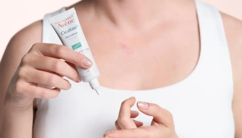 Une femme applique le gel cicatriciel Avène Cicalfate+, la meilleure crème pour cicatrice après opération, sur une légère cicatrice.