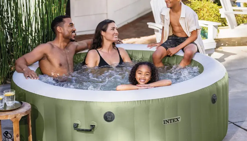Famille souriante profitant d'un moment de détente dans un spa gonflable vert, créant une bulle de bonheur et d'isolation.