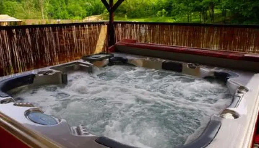 Jacuzzi extérieur bouillonnant, prêt pour la détente. La réglementation pour ces installations est importante pour la sécurité.
