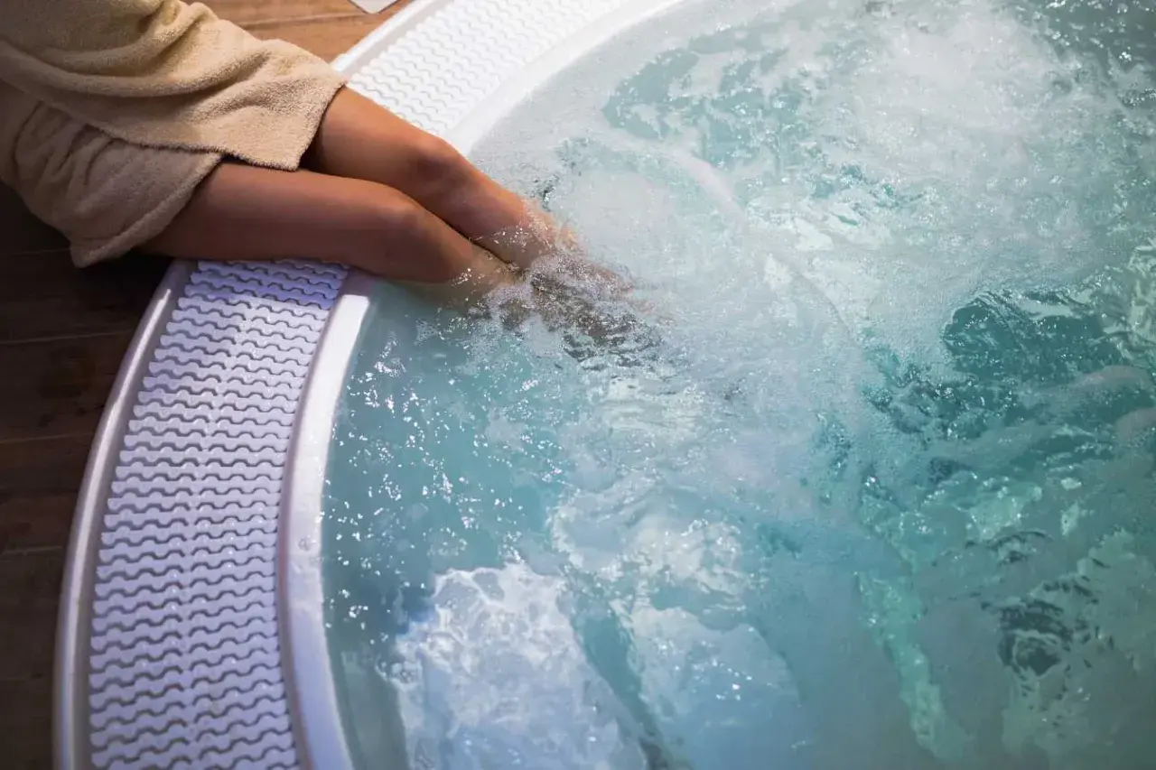 Personne dans un jacuzzi bouillonnant. Pour savoir comment éteindre un jacuzzi, consultez le manuel d'utilisation.
