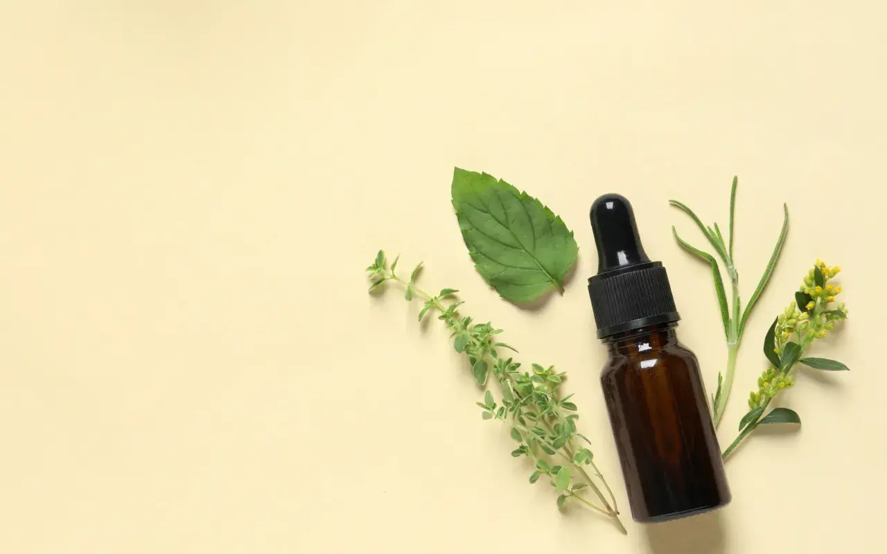Flacon d'huile essentielle avec des herbes. Un remède naturel pour la toux sèche.
