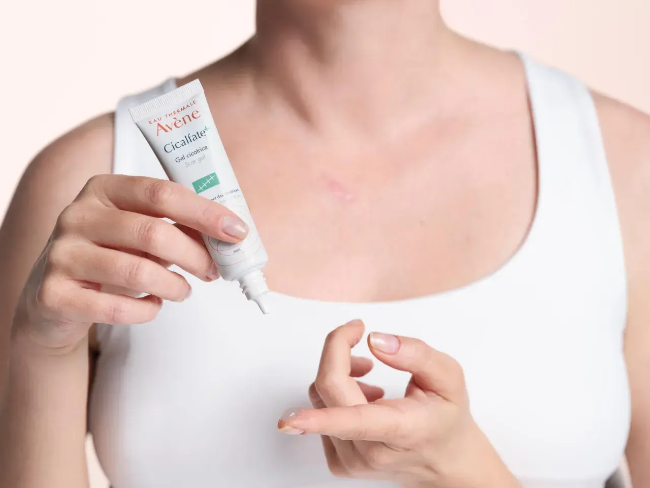 Une femme applique le gel cicatriciel Avène Cicalfate+, la meilleure crème pour cicatrice après opération, sur une légère cicatrice.