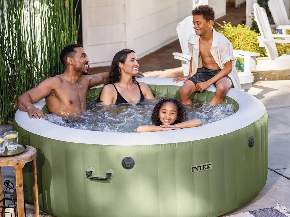 Famille souriante profitant d'un moment de détente dans un spa gonflable vert, créant une bulle de bonheur et d'isolation.