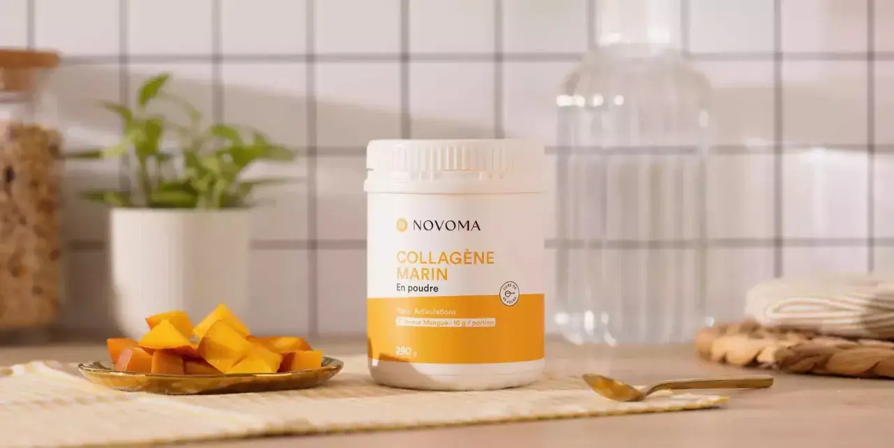 Un pot de cure de collagène marin en poudre saveur mangue, accompagné de dés de mangue fraîche.