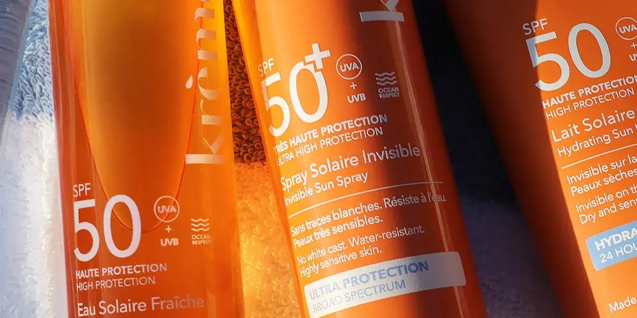 Trois tubes de cr&egrave;me solaire orange, avec indication SPF 50. Parfait pour une protection optimale, que ce soit SPF 30 ou 50.