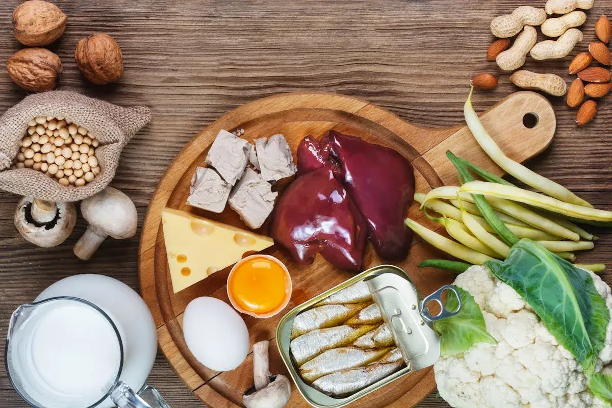 Assortiment d'aliments riches en vitamine B7 : foie, levure, &oelig;ufs, sardines, noix, amandes, haricots, chou-fleur, champignons, fromage, lait et soja.
