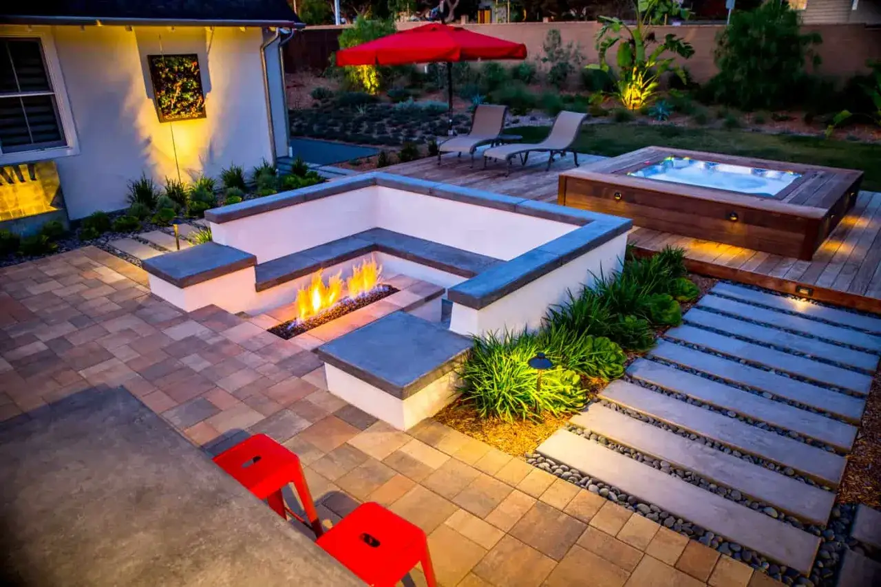 Un espace ext&eacute;rieur moderne avec un foyer int&eacute;gr&eacute;, un spa en bois et des si&egrave;ges. Id&eacute;al pour savoir comment monter un spa et profiter de soir&eacute;es conviviales.